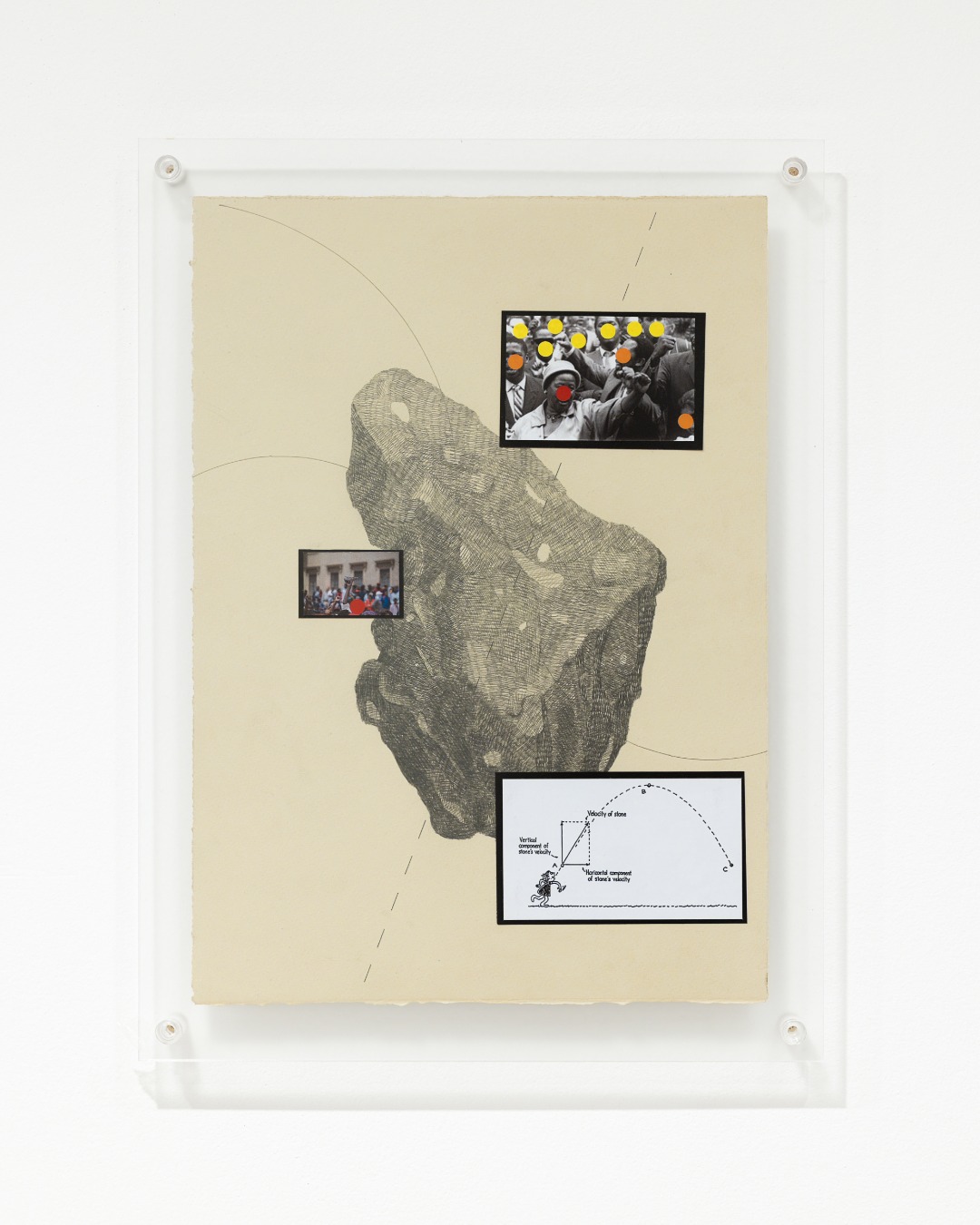 A framed mixed-media artwork on cream-colored paper features a detailed black-and-white drawing of a large, irregular rock-like form, overlaid with curved lines and dashed marks. Three small black-bordered images are arranged across the composition: a black-and-white photograph of a crowd with yellow, orange, and red dots marking several figures, a color photograph of a gathering, and a diagram illustrating the trajectory of a thrown stone. The artwork is mounted behind a clear acrylic panel with visible fasteners against a white gallery wall.